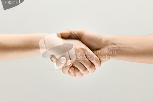 Image of Two male hands shaking isolated on grey studio background