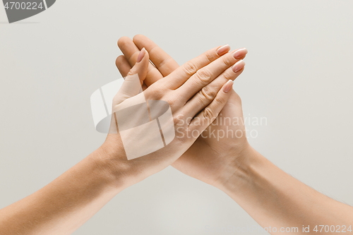 Image of Male and female hands demonstrating a gesture of getting touch isolated on gray background