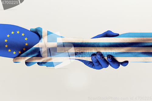 Image of Male hands holding colored in blue EU and Greece flag