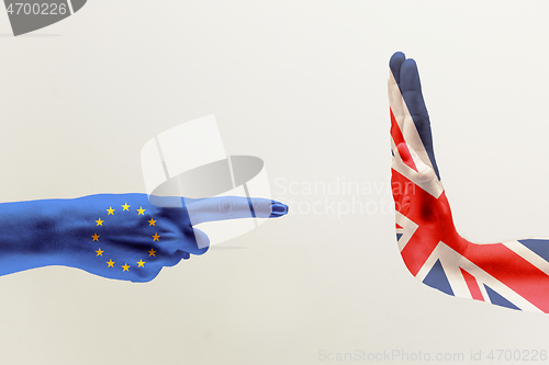 Image of Male hands colored in United Kingdom and European Unity flags