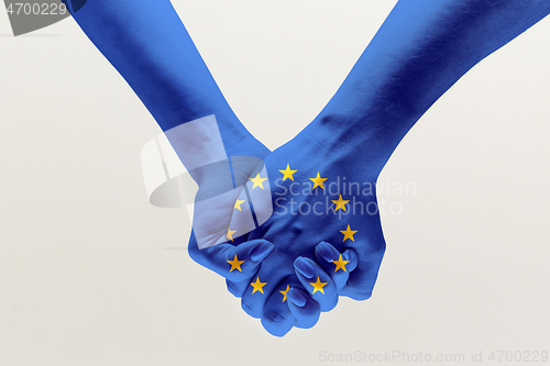 Image of Human hands holding colored in blue EU flag