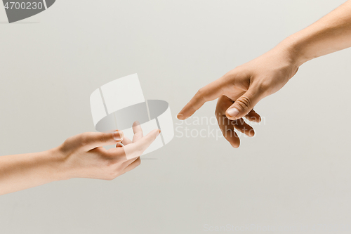 Image of Two male hands trying to touch isolated on grey studio background