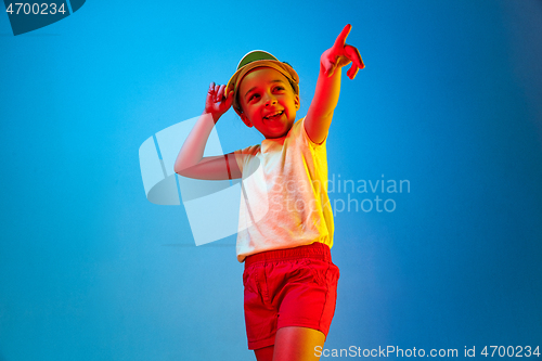 Image of The happy teen girl standing and smiling against blue background.