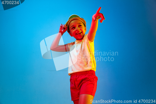 Image of The happy teen girl standing and smiling against blue background.