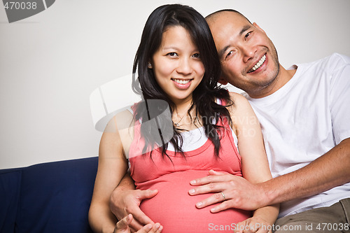 Image of Happy expecting pregnant asian couple