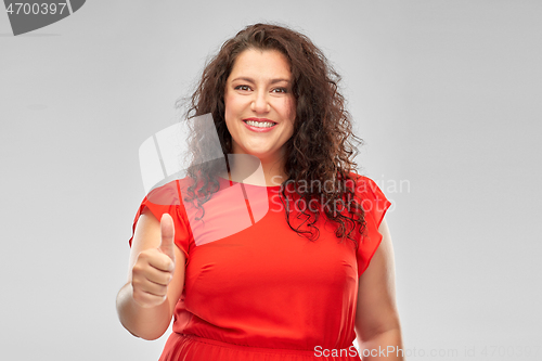 Image of happy woman in red dress showing thumbs up