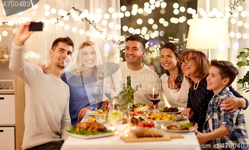 Image of family having dinner party and taking selfie