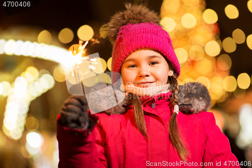 Image of happy girl with sparkler at christmas market