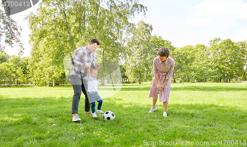 Image of happy family playing soccer at summer park