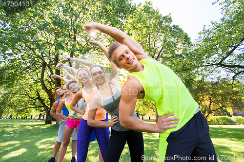 Image of group of happy people exercising at summer park