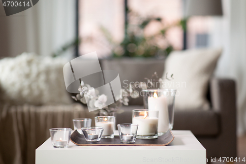 Image of burning fragrance candles on table at cozy home