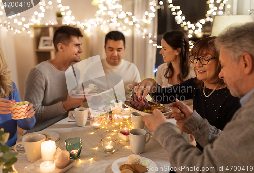 Image of happy family having tea party at home