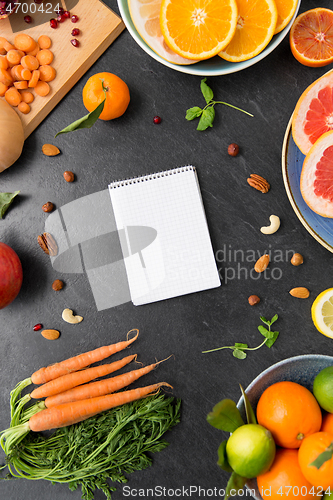 Image of close up of notebook, fruits and vegetables