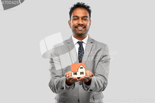 Image of man realtor with house model and folder