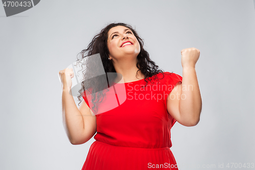 Image of happy woman in red dress celebrating success