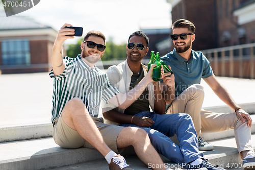 Image of men toasting beer and taking selfie by smartphone