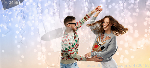 Image of couple dancing at christmas ugly sweaters party