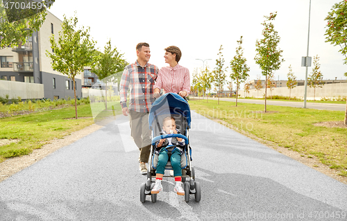 Image of family with baby and stroller walking along city
