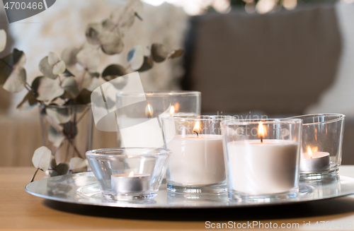 Image of burning fragrance candles on table at cozy home