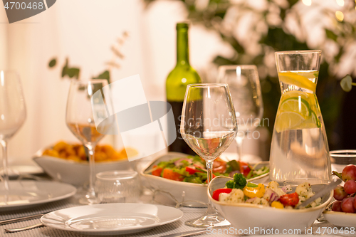 Image of table served with plates, wine glasses and food