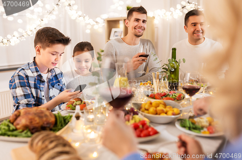 Image of children with smartphone at family dinner party