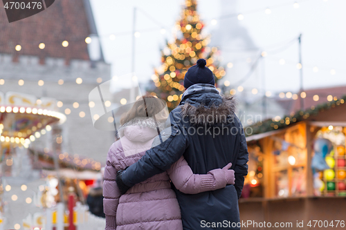 Image of happy senior couple hugging at christmas market