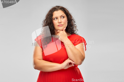 Image of serious woman in red dress thinking