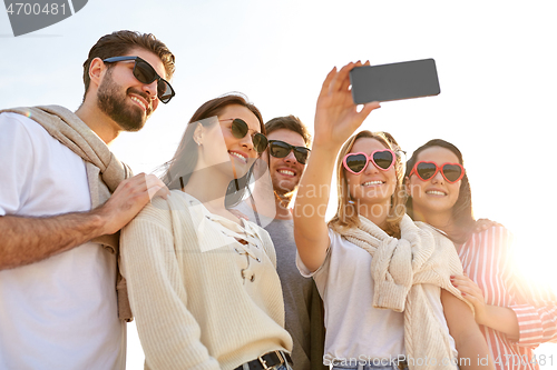 Image of happy friends taking selfie in summer