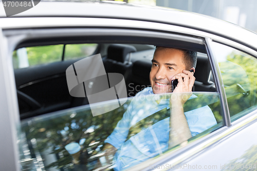 Image of male passenger calling on smartphone in taxi car