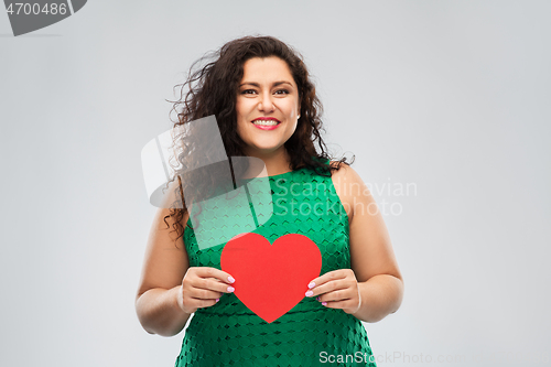 Image of happy woman in green dress holding red heart
