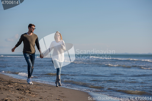 Image of Loving young couple on a beach at autumn sunny day