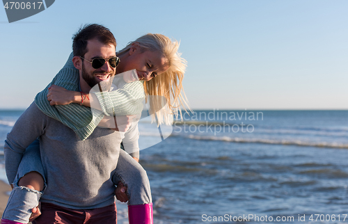 Image of couple having fun at beach during autumn