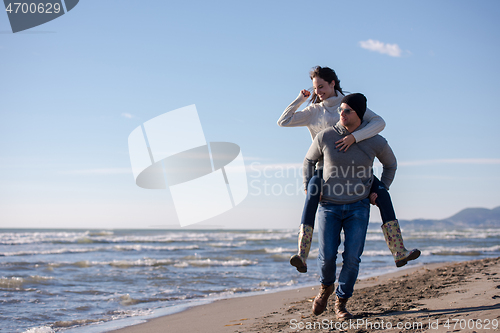 Image of couple having fun at beach during autumn