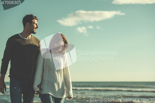 Image of Loving young couple on a beach at autumn sunny day