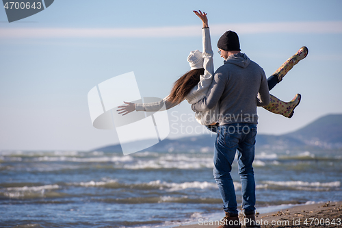 Image of Loving young couple on a beach at autumn sunny day