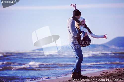 Image of Loving young couple on a beach at autumn sunny day