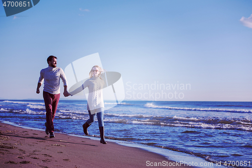 Image of Loving young couple on a beach at autumn sunny day