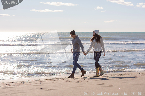 Image of Loving young couple on a beach at autumn sunny day