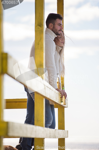 Image of young couple drinking beer together at the beach