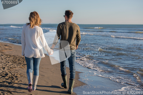 Image of Loving young couple on a beach at autumn sunny day