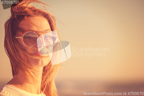 Image of Young woman enjoying the warm autumn day