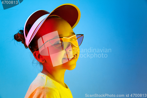 Image of The happy teen girl standing and smiling against blue background.