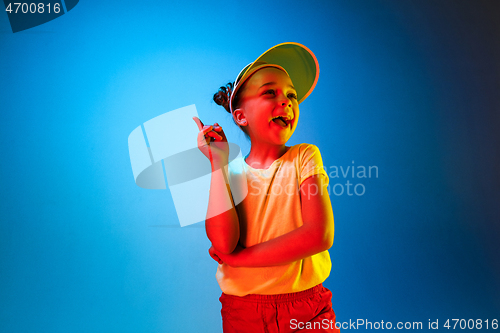 Image of The happy teen girl standing and smiling against blue background.