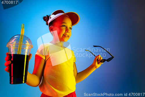 Image of The happy teen girl standing and smiling against blue background.