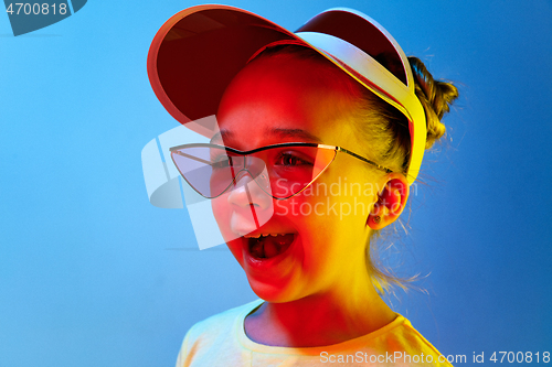 Image of The happy teen girl standing and smiling against blue background.