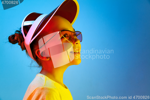 Image of The happy teen girl standing and smiling against blue background.