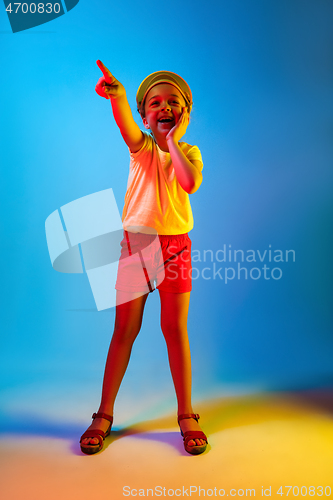 Image of The happy teen girl standing and smiling against blue background.