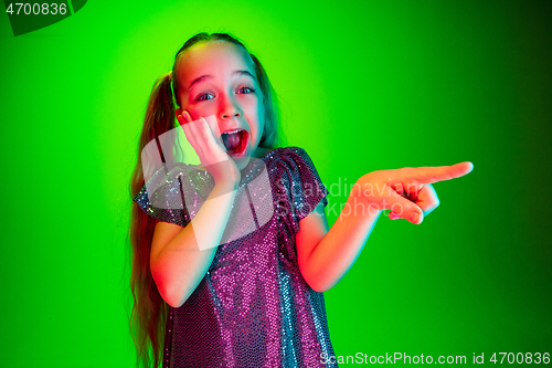 Image of Beautiful teen girl looking suprised isolated on green