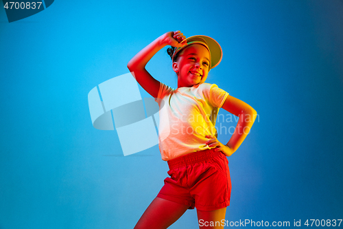 Image of The happy teen girl standing and smiling against blue background.