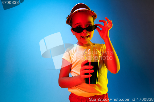 Image of The happy teen girl standing and smiling against blue background.